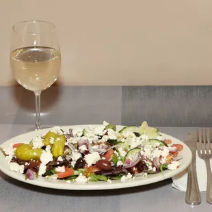 a plate of salad and a glass of wine