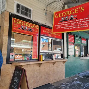 a man standing in front of a sandwich shop