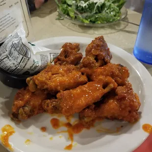 a plate of chicken wings and a bottle of beer