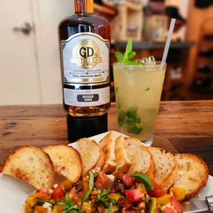 a plate of food and a bottle of gin