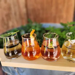 a row of glasses of different drinks