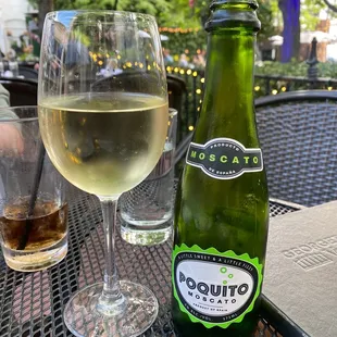 a glass of wine and a bottle of white wine
