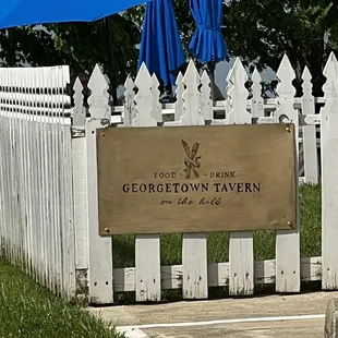a white picket fence with blue umbrellas