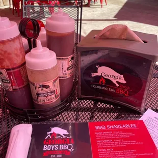 a table with bbq&apos;s and barbecue sauces