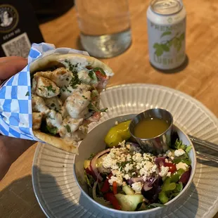 Tender chicken souvlaki pita sandwich with fresh Greek salad. They also do the chicken as skewers for dinner.