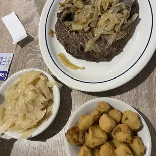 a steak with onions and potatoes