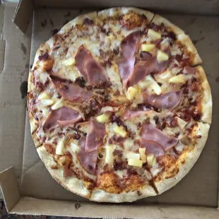 a pizza with ham and pineapples
