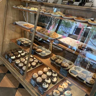 a display case of cupcakes and pastries