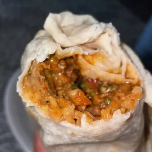 a hand holding a burrito