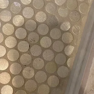 black specks on tile and grout covering up some of the penny tiles