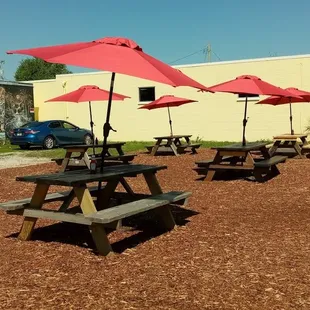 picnic tables and umbrellas in front of a building