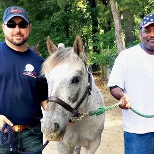 Clients of Alpha Omega Veterans Services leading horses at the Germantown Charity Horse Show with Southern Reins Center for Equine Therapy