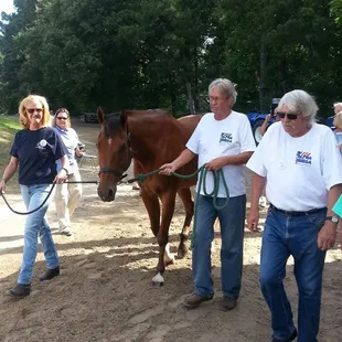 Clients of Alpha Omega Veterans Services leading horses at the Germantown Charity Horse Show with Southern Reins Center for Equine Therapy