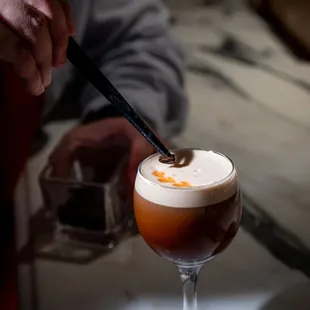 a person stirring up a drink