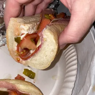 a person taking a sub from a paper plate