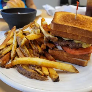 Melting Point! A crazy delicious burger nestled between to grilled cheeses severed with from-scratch fries.