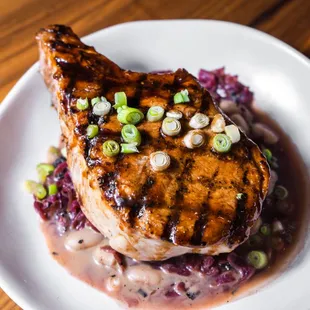 a pork chop on a bed of red cabbage