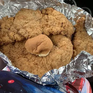 a fried chicken sandwich wrapped in tin foil