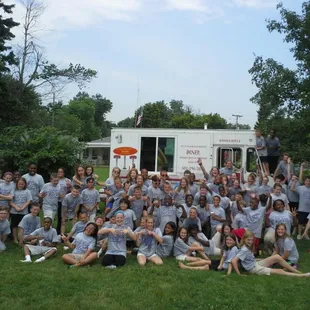 a group of people posing in front of a food truck