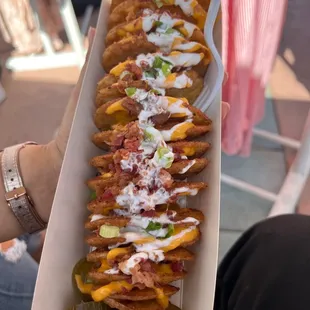 Potato twist with sour cream, bacon (extra $1), green onions, cheese and jalapeños