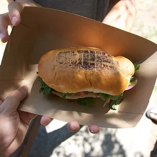 a person holding a sandwich