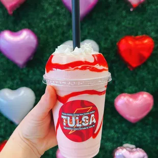 a hand holding a cup of milkshake