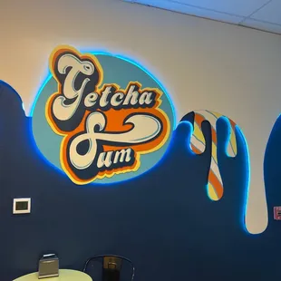 a blue wall with a sign that says getcha sum