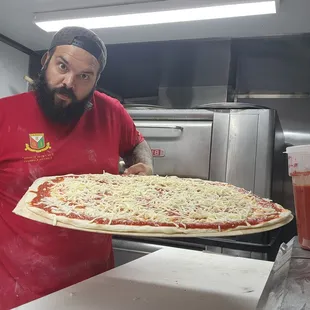 a man holding a large pizza