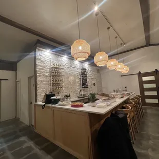 a bar with stools and a wine rack