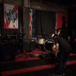 a man playing drums in a dark room