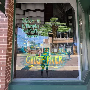 the reflection of a ghost river sign in the window