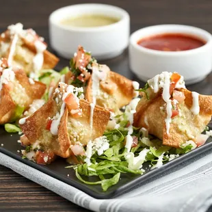 Taquito Dumplings are filled with potato, corn, chicken and jalapeno, and topped with salsa verde and wasabi sour cream.