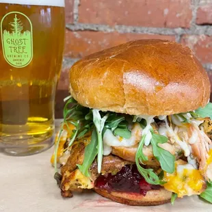 a chicken sandwich and a glass of beer