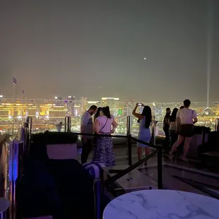 a group of people standing on a rooftop at night