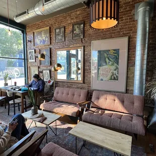 two people sitting on couches in a coffee shop