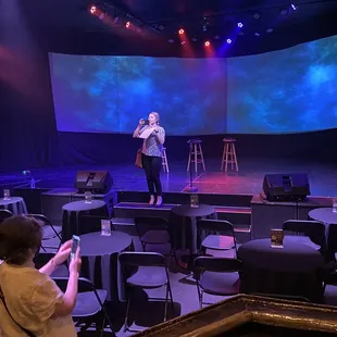a woman standing on stage in front of a screen
