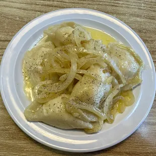 Potato and cheese pierogies with onions and butter.