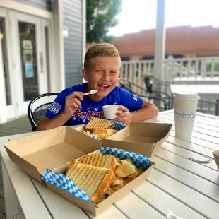 a young boy eating a sandwich