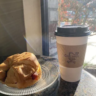 Egg bacon and cheese croissant paired with a 16 ounce coffee with oat milk.