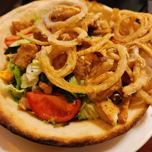Large salad with fried onion rings.