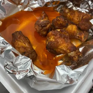 a tray of chicken wings covered in sauce
