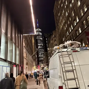 people walking down a city street at night