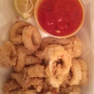 Soggy, rubbery Calamari I ordered for pick up  this is 30 minutes after I placed the order! notice the 2 burnt fries at the bottom WTF!