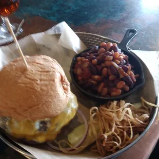 a hamburger and beans on a plate