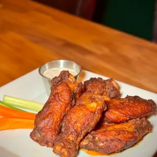 a plate of chicken wings and carrots