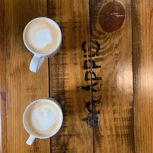 two cups of coffee on a wooden table