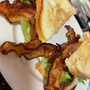 a plate of bacon and a sandwich