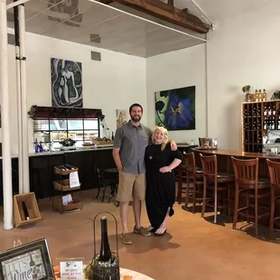a man and a woman standing in a tasting room