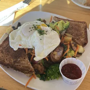 Curried vegetable hash with over-easy eggs. Broccoli, spinach, carrot, mushroom, roasted red potatoes, toast and jam.