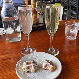 a plate of food and two glasses of wine